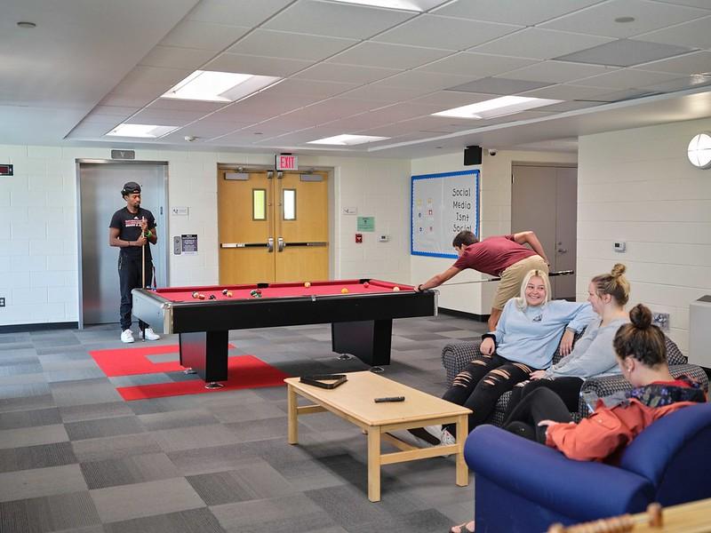 Students playing pool in the lounge of Cook/Meijer Hall 