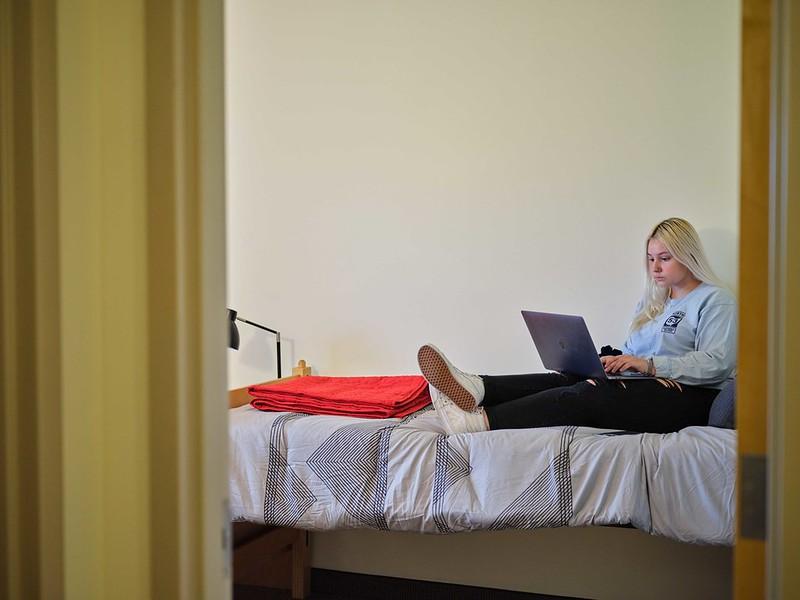 Student on her laptop on her bed