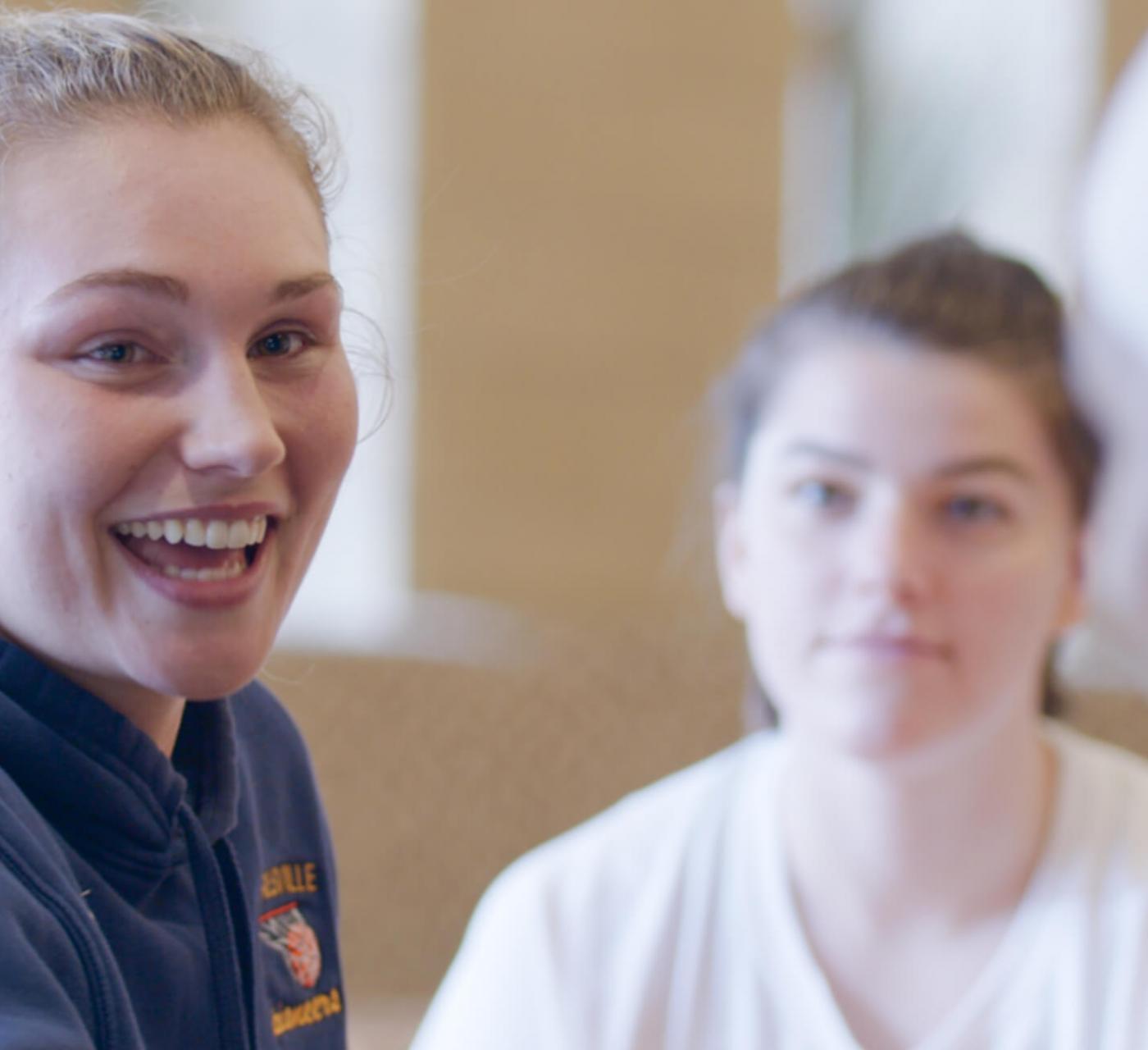 student smiling in dining hall with friends